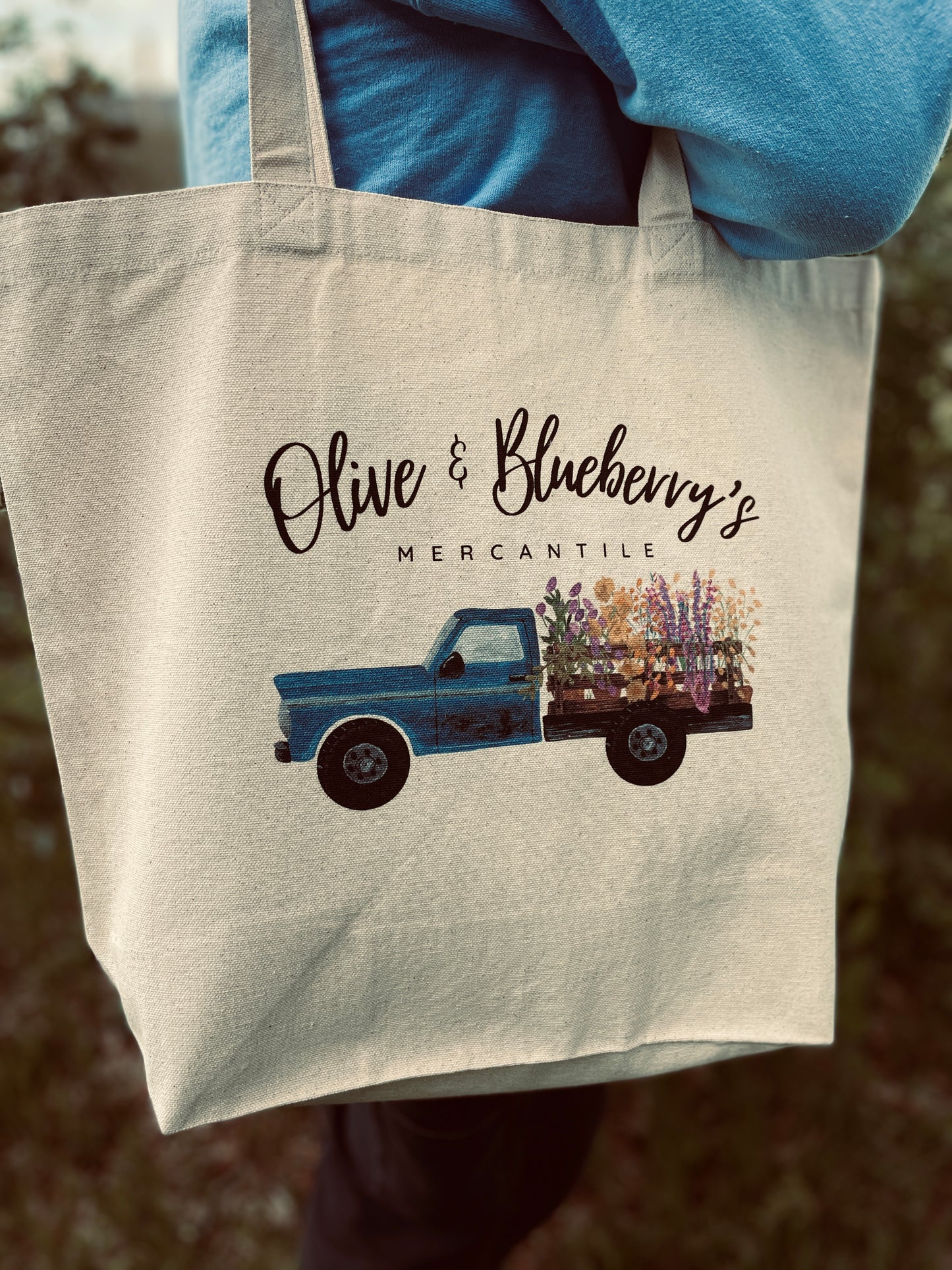Double sided cotton canvas tote bag showing blue farm truck logo on both sides
