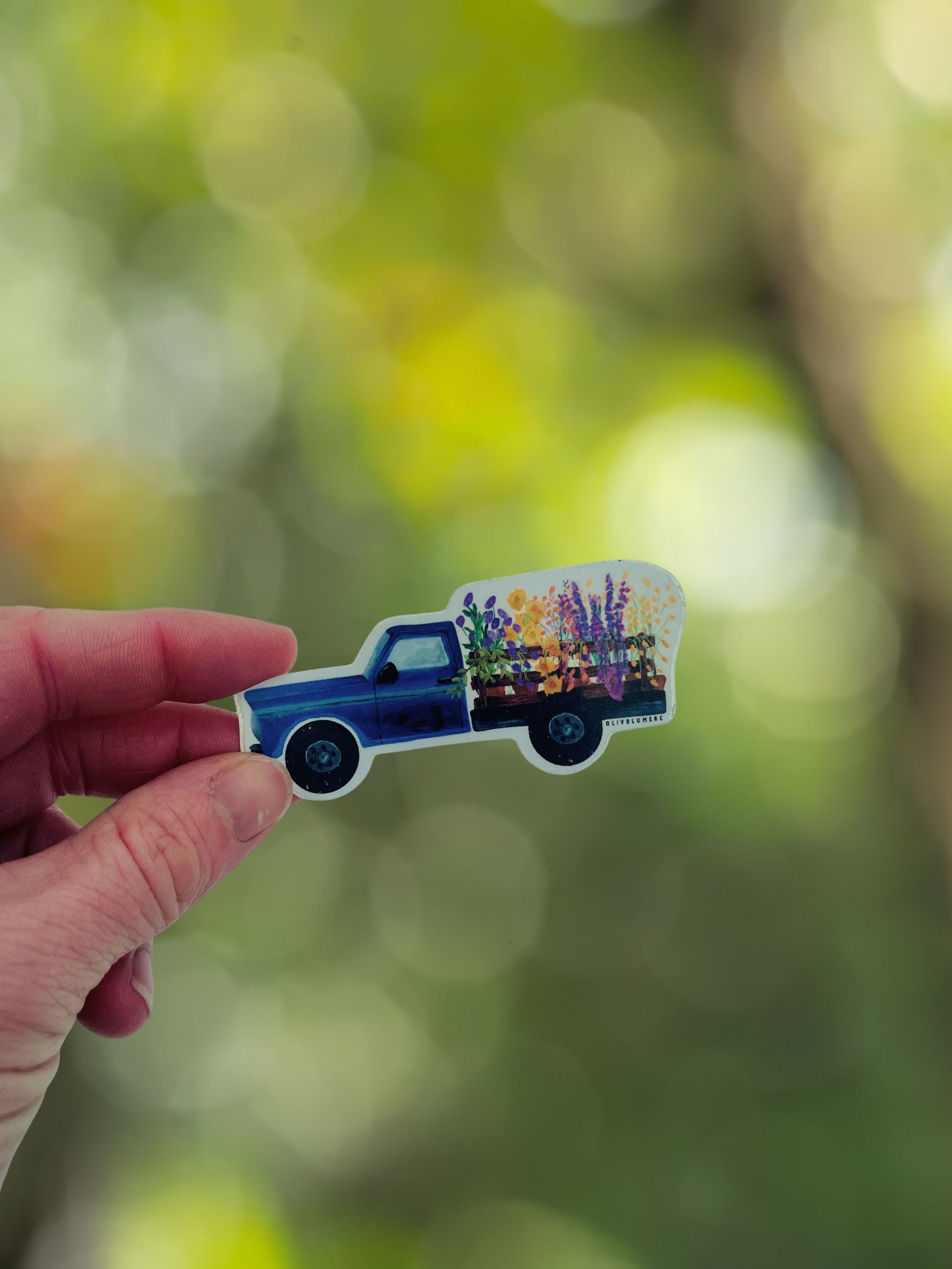 Close-up of a blue farm truck flower sticker showing illustrated details.